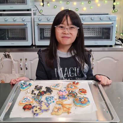 Child baking and displaying decorated cookies in a kitchen setting the bear bakery