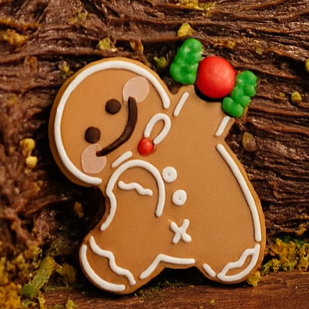 Chocolate cake with Christmas decorations including a snowman and gingerbread man on a dark background