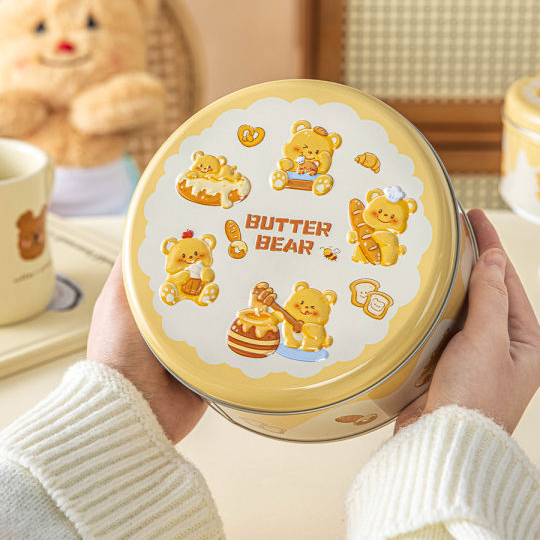 Person holding a 'Butter Bear' container with teddy bear illustrations on a soft background